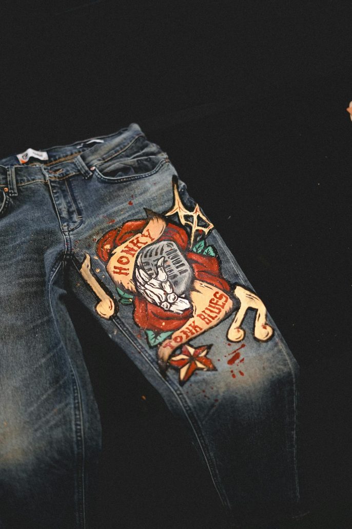 Explore this unique pair of jeans featuring a hand-painted artistic design, perfect for fashion enthusiasts.
